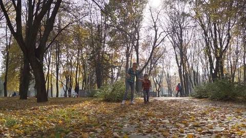 Young mother having fun with her son in autumn park at sunny day Vídeo Stock 97147223