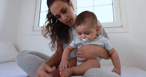 Young mother having fun with her son in bed at home Stock Footage 168816169