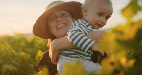 Young mother having fun time with her little baby boy in summer vineyard of 動画素材 203839467