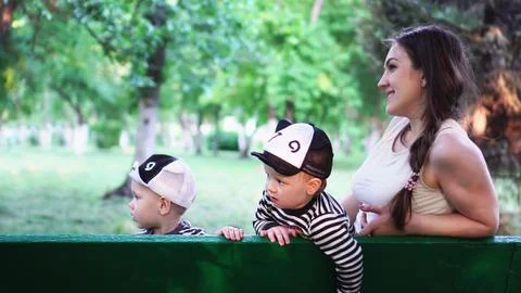 Young mother having fun with two kids sitting in the park Foto stock