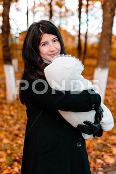 Young mother with her little baby on hand in autumn park Stock Photos