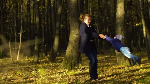Young mother with her son playing in autumn park 4k Stock Footage 83106787