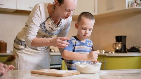 Young mother with her son preparing a pie in the kitchen. Stock Footage 100765627