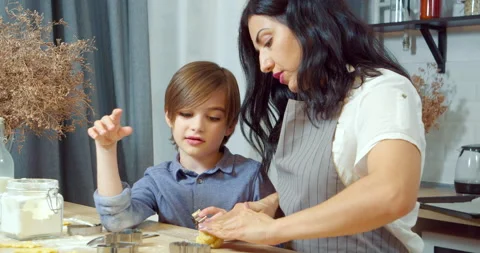 Young mother with her son preparing homemade cookies kneading dough Stock Footage 131460983