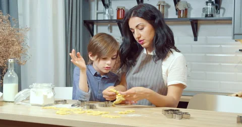 Young mother with her son preparing homemade cookies in the kitchen Stock Footage 132522573
