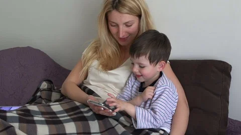 Young mother with her son watching photos on the mobile phone Stock Footage 74436062