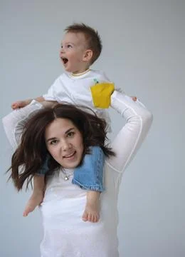 Young mother with her two year old son, dressed in the same style, relaxing and Stock Photos