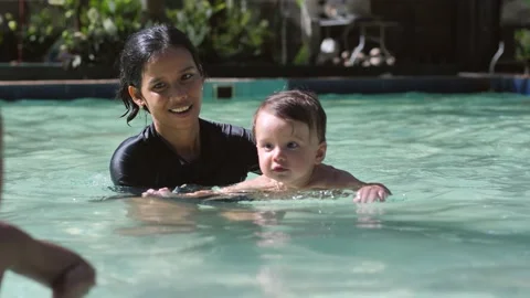 A young mother holds her son with both hands in the water in the pool. A 10 Stock Footage 202495784