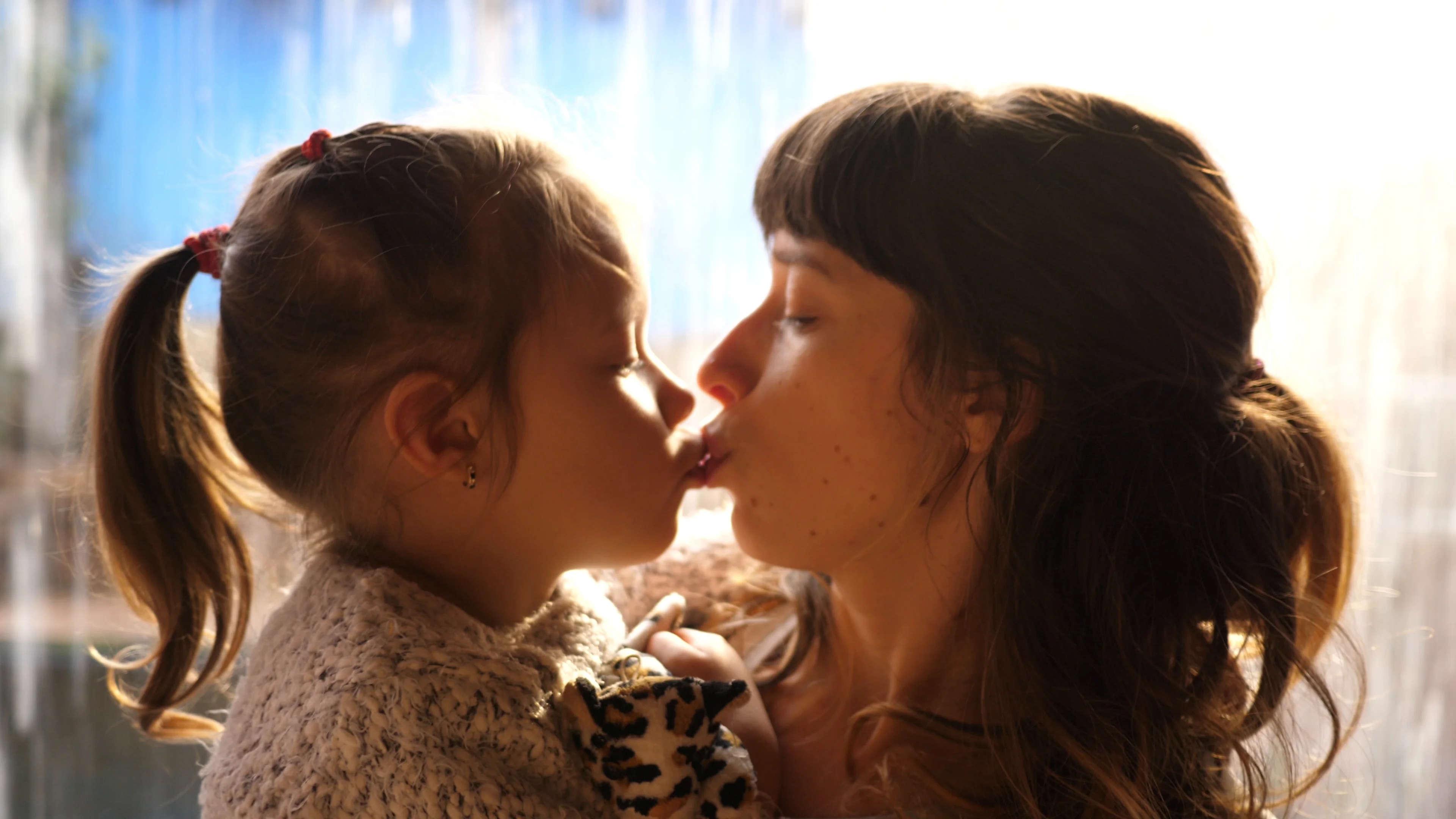 mom daughter kiss Getty Images
