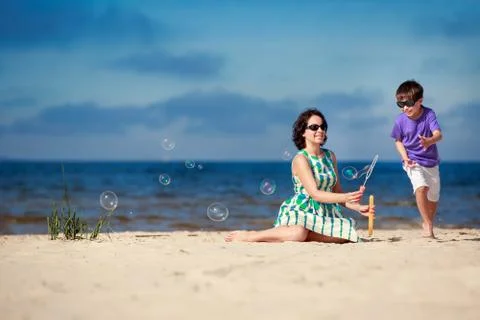 Young mother making soap bubbles with his child Stock Photos