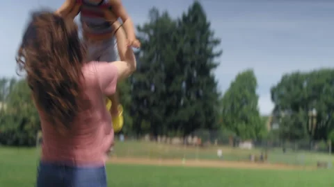 A young mother picks up and throws her son up in the air and catches him Video stock 143621950