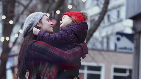 A young mother playing and cuddling with her little daughter outdoor, holding Stock Footage 104443904