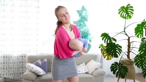 Young mother playing with her 6 months son in the room slow motion Stock Footage 75018997