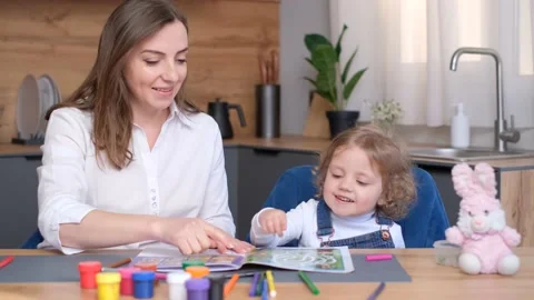 A young mother plays educational games with her daughter while sitting at the Stock Footage 237694294
