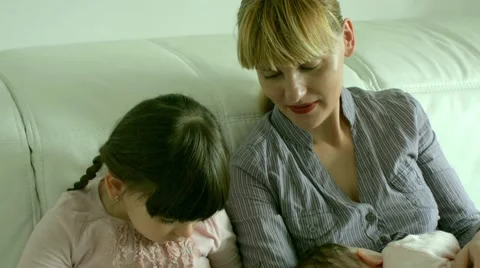 Young mother sitting on sofa with two daughters Stock-Footage 46678491