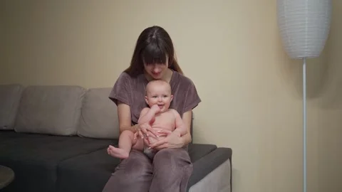 A young mother spends time with her baby, playing with her legs Vidéo 237029058