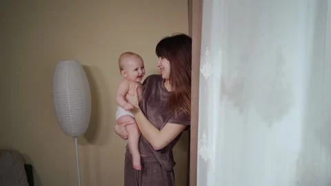 Young mother spends time with her cute baby, gently kisses and plays Vidéo 237029392