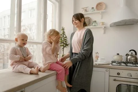 A young mother spends time with her little daughters at home. Foto stock