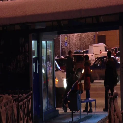 Young mother with a stroller at a bus stop on a winter evening. Stock Footage 69722761