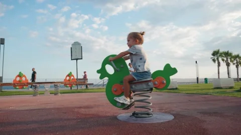 Young mother supporting her son on the playground. Children playing outdoor Video stock 254781875