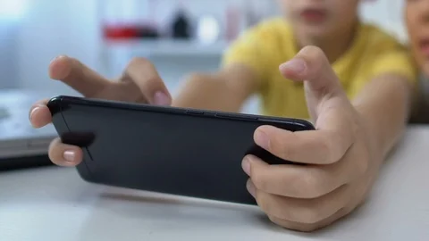 Young mother supporting small son during video game playing on smartphone Vídeo Stock 119036211