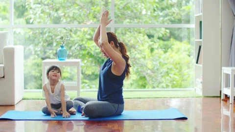 Young mother is teaching basic yoga postures for daughter Stock Footage 117887118