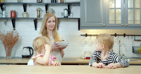 Young mother treating two cute daughters to freshly baked homemade cookies Stock Footage 132291210