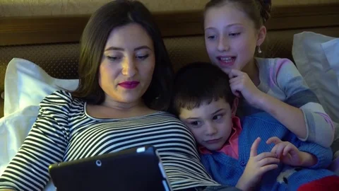 A young mother with two children lying in hotel in bed. Stock Footage 74284046