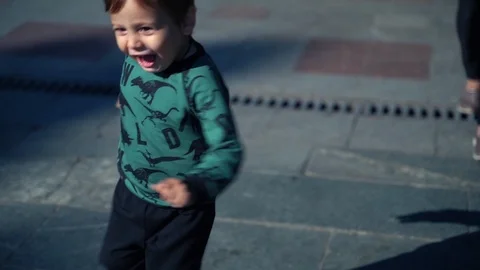 A young mother with a two year old son walks in the city. Sunny warm day in the Stock Footage 118549083