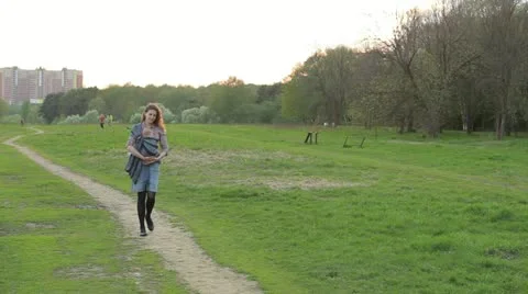 Young mother walking with baby in sling outdoors in park. Stock Footage