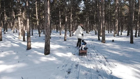 A young mother in a white down jacket runs through the delightfully beautiful Video stock 104621632
