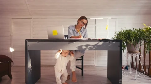 A young mother is working at home using computer while she's taking care of her 스톡 동영상 165307221