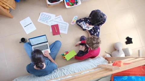 Young mother working at home while taking care of her sons Vídeos de archivo 270483636