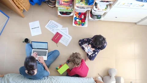 Young mother working at home while taking care of her sons Vídeos de archivo 270483701