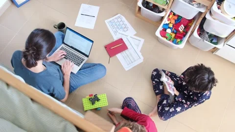 Young mother working at home while taking care of her sons Vídeos de archivo 270483722