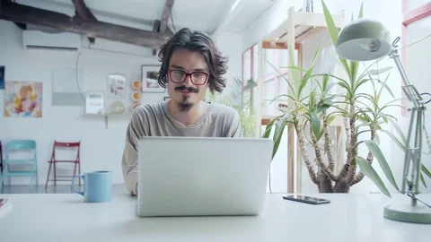 Young motivated hipster working in computer or laptop with a cup a tea or coffee Stock Footage 98896017