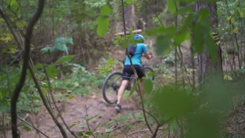Young mountain biker pushes mountain bike uphill on the forrest Stock Footage 162032762
