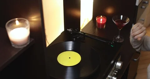 Young move tone arm on turntable and play music from vinyl record Stock Footage 120585061