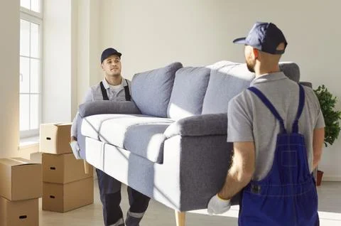 Young mover men service sofa furniture moving, individual, company workers carry Stock Photos