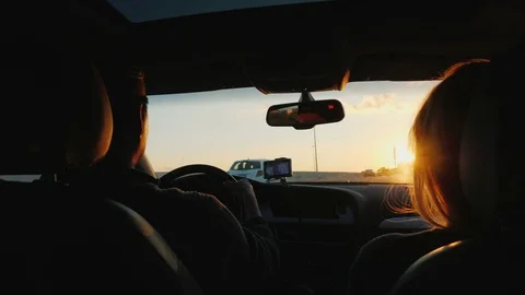 A young multi-ethnic couple is driving to the car in a sunset. The light Stock Footage 82575435