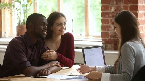 Young multi-ethnic couple planning mortgage meeting with real estate agent Stock Footage