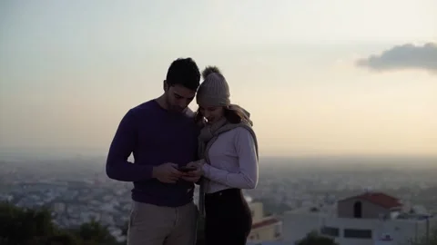 Young multi-ethnic couple using smartphone and text messaging outdoors Stock Footage 133280508