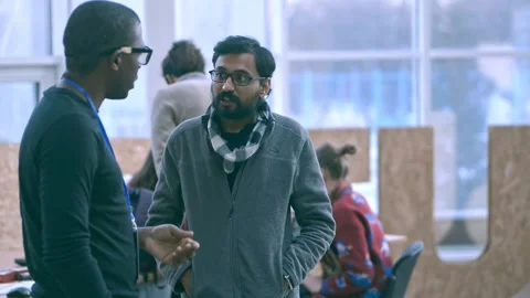 Young multi-ethnic guys are talking about startup, standing in modern office Stock Footage 137560920
