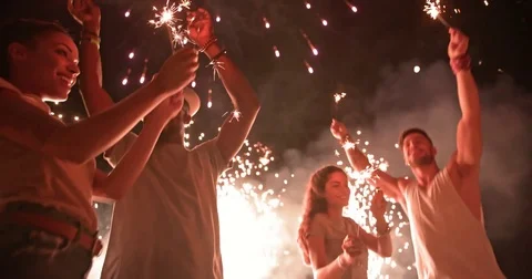 Young multi-ethnic hipster friends celebrating fourth of July with fireworks Stock Footage