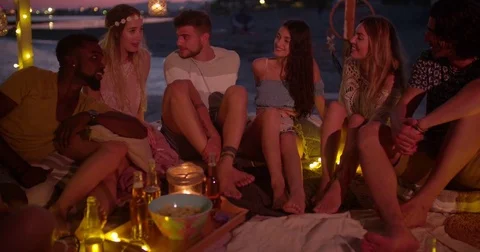 Young multi-ethnic hipster friends having fun at night beach party Stock Footage