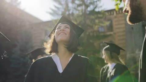 Young multi ethnical graduates in caps laughing out loud and having fun on their Stock Footage
