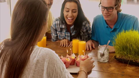 A young multicultural group of friends lighting the candles, just before celebra Stock Footage 199633635