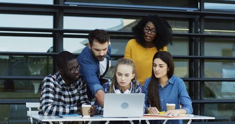 Young multiethnic co-workers discussing their with a laptop computer on the Video stock 90224983