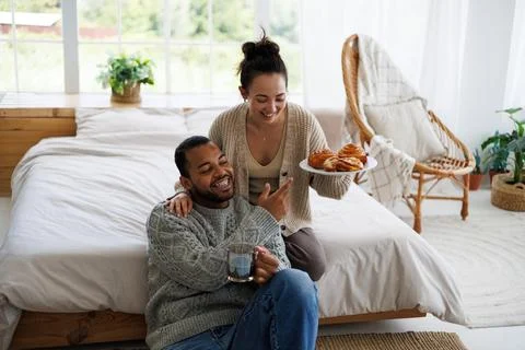 Young multiethnic couple with coffee at home Foto stock