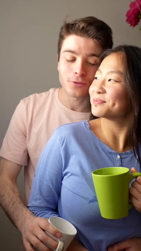 Young multiethnic couple drinking coffee at home Stock Footage 305237110